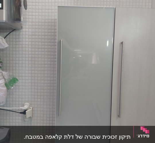 דלת זכוכית חלבית עם ידית מתכת במטבח